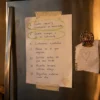 Cartel de reglas escrito a mano y pegado con cinta en la puerta de una nevera