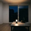 Salón de un piso moderno iluminado solo con un farol LED durante un apagón, con una radio a pilas sobre la mesa